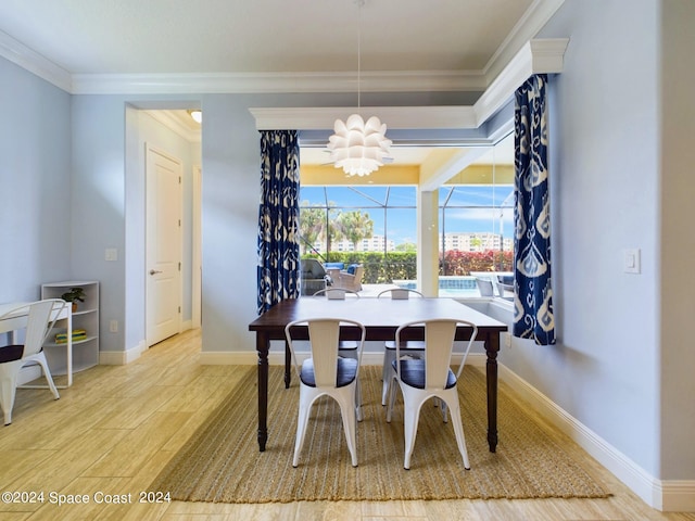 dining space with ornamental molding, a chandelier, and light hardwood / wood-style flooring