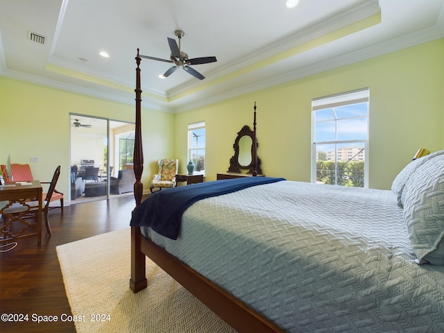 bedroom featuring ceiling fan, a tray ceiling, dark hardwood / wood-style floors, and crown molding