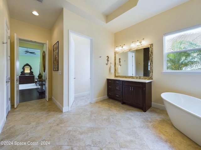 bathroom with ceiling fan, vanity, and a tub to relax in