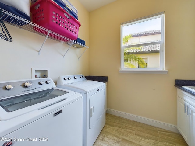 laundry room featuring washing machine and dryer and cabinets