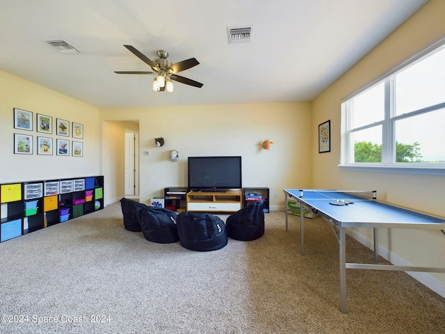 recreation room with ceiling fan and carpet