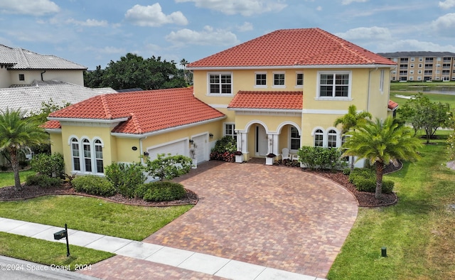 mediterranean / spanish-style house featuring a front yard and a garage