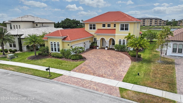 mediterranean / spanish-style home with a garage and a front lawn