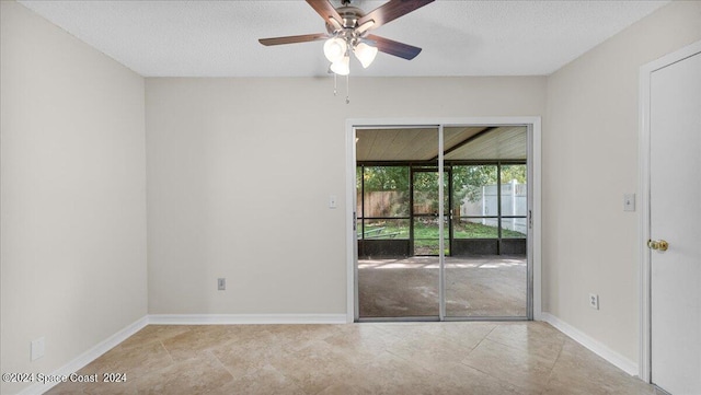 empty room with light tile patterned floors, a textured ceiling, and ceiling fan