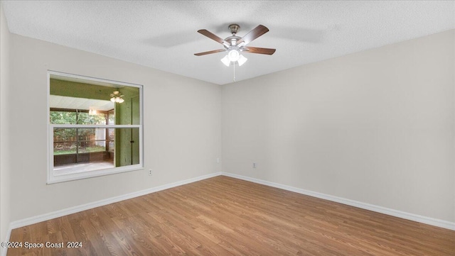 spare room with ceiling fan, a textured ceiling, and light wood-type flooring