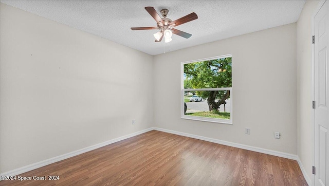 spare room featuring ceiling fan, hardwood / wood-style floors, and a textured ceiling