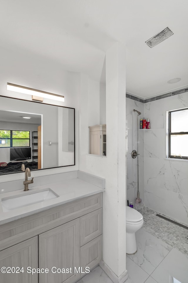 bathroom featuring visible vents, vanity, toilet, marble finish floor, and a marble finish shower