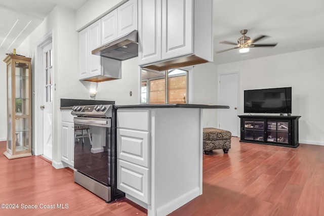 kitchen with white cabinets, light wood finished floors, under cabinet range hood, and electric range