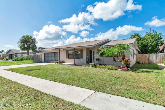 single story home featuring a garage and a front lawn