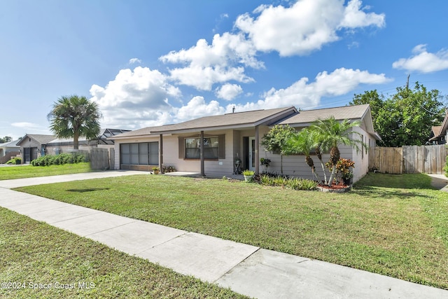 ranch-style home featuring a garage, a front lawn, fence, and concrete driveway