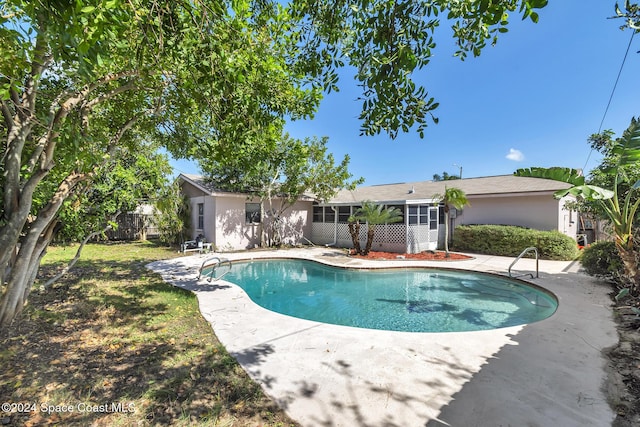 pool with a patio, fence, and a sunroom