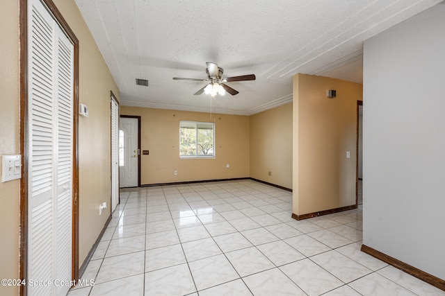 unfurnished room featuring a textured ceiling, ornamental molding, ceiling fan, and light tile patterned floors