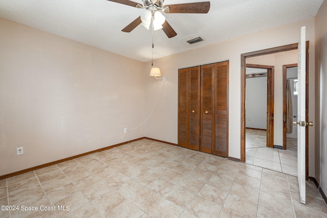 unfurnished bedroom featuring ceiling fan and a textured ceiling