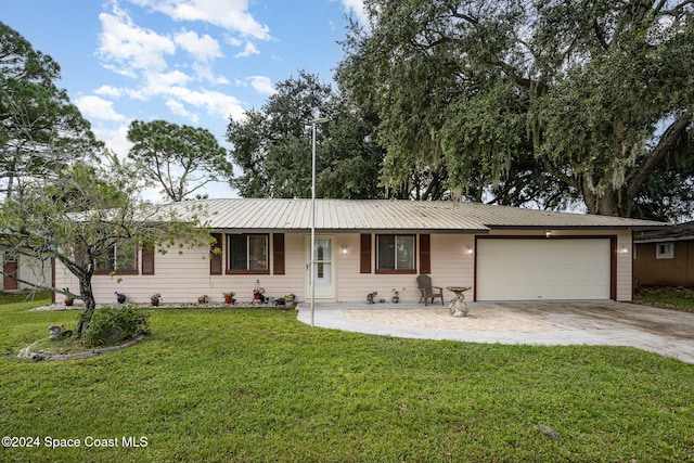 ranch-style house featuring a garage and a front lawn