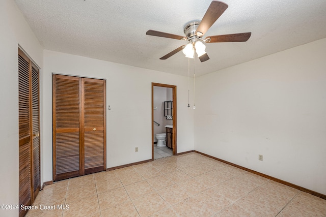 unfurnished bedroom featuring a textured ceiling, light tile patterned floors, ceiling fan, and connected bathroom