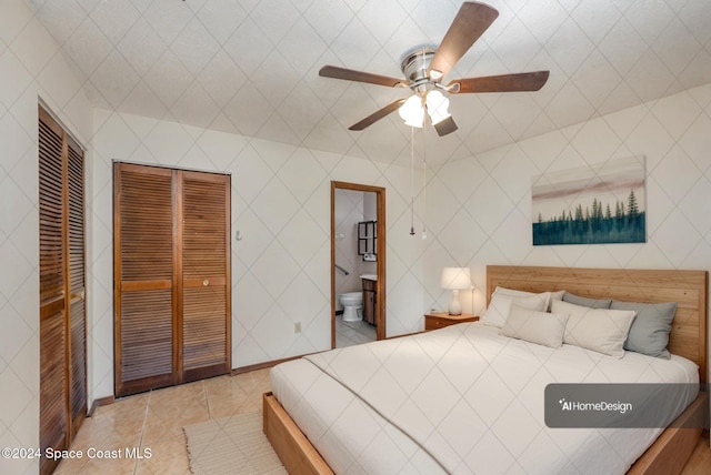 bedroom with ceiling fan, ensuite bath, light tile patterned floors, and tile walls