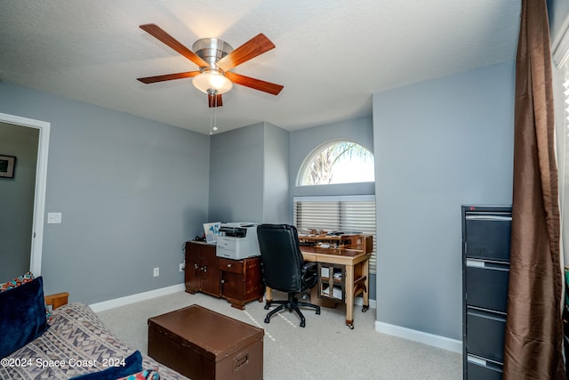 carpeted home office with a textured ceiling and ceiling fan