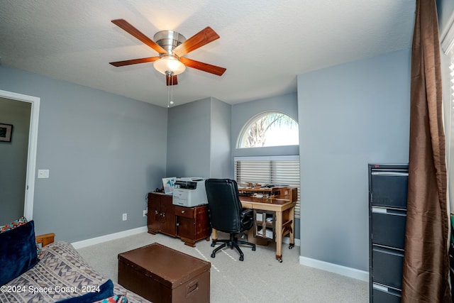 carpeted office with ceiling fan and baseboards