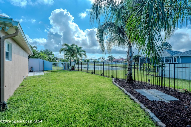 view of yard featuring a water view and a fenced backyard