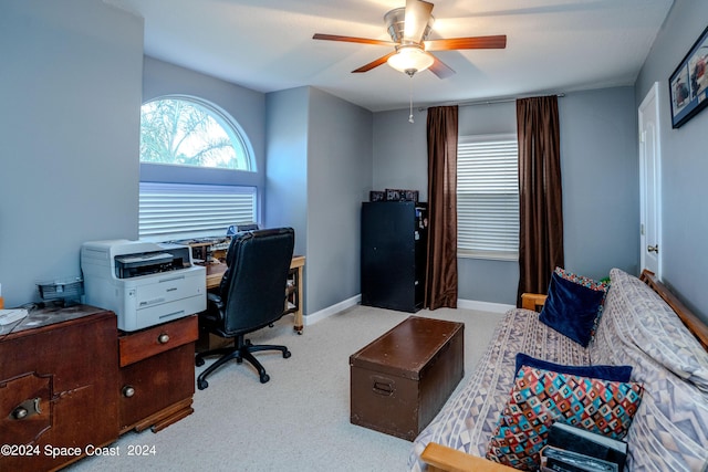 carpeted home office with baseboards and ceiling fan