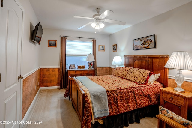 carpeted bedroom with wooden walls and ceiling fan