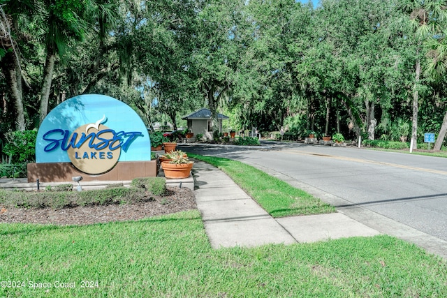 community / neighborhood sign featuring a yard