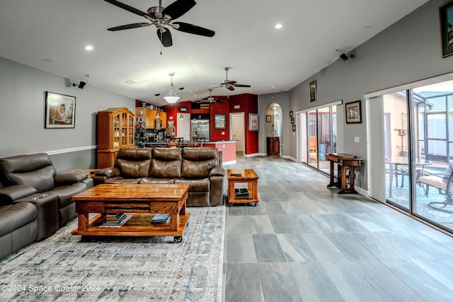 living area featuring recessed lighting, a ceiling fan, arched walkways, and vaulted ceiling