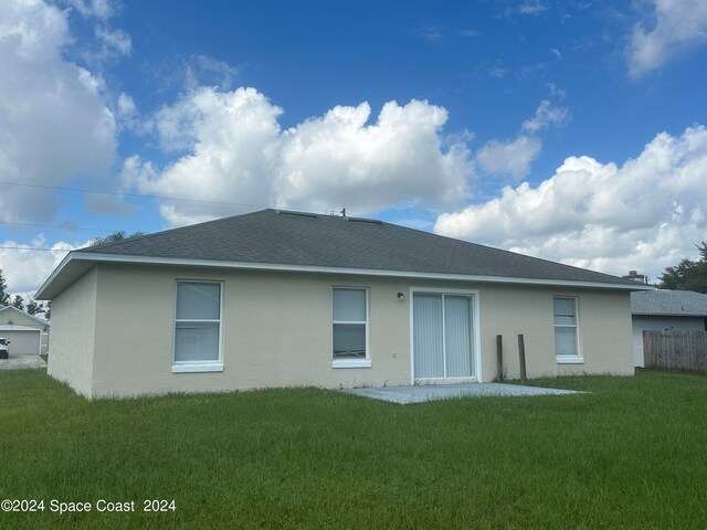 rear view of property featuring a yard and a garage