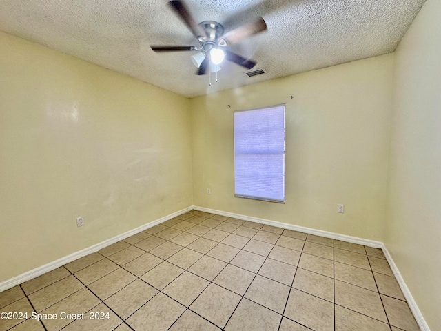 tiled empty room featuring ceiling fan and a textured ceiling