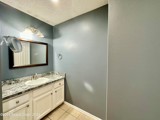 bathroom with tile patterned flooring, vanity, and a textured ceiling