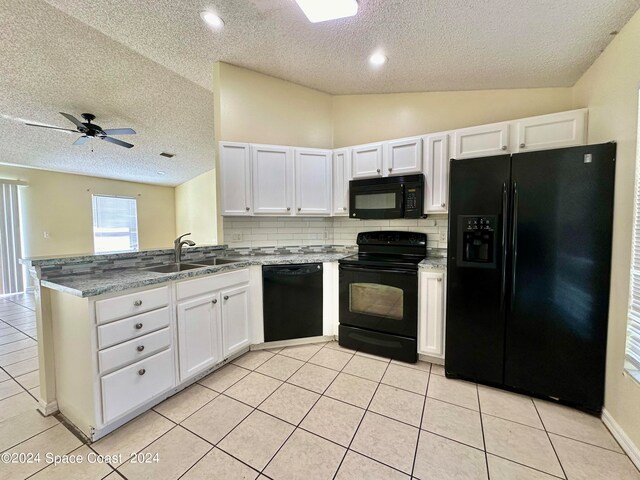 kitchen featuring vaulted ceiling, a textured ceiling, white cabinetry, and black appliances