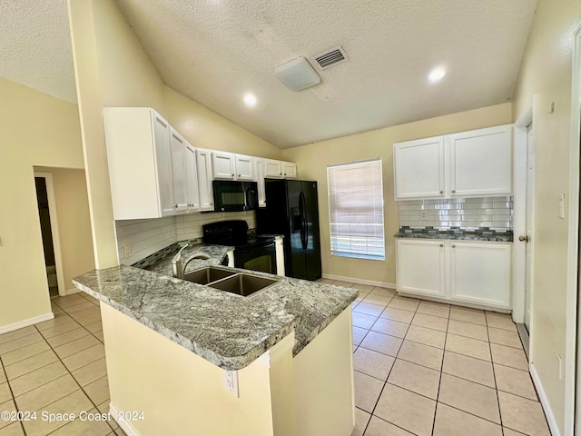 kitchen featuring light stone counters, lofted ceiling, kitchen peninsula, white cabinetry, and black appliances