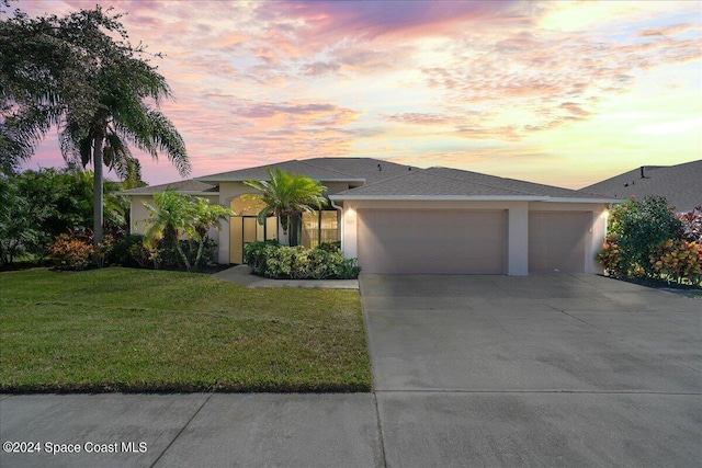 view of front of house with a yard and a garage