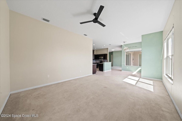 unfurnished living room with light carpet and ceiling fan