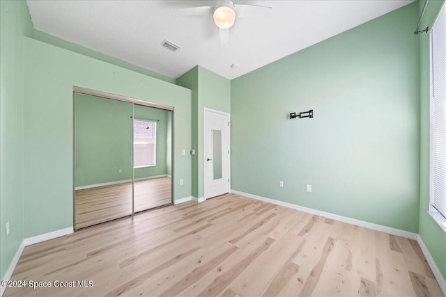 unfurnished bedroom featuring a closet, light wood-type flooring, and ceiling fan