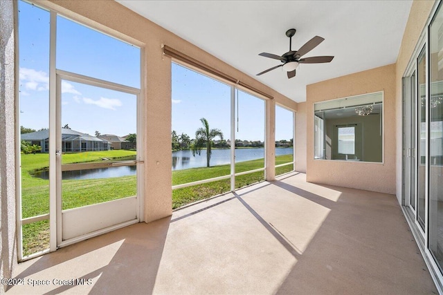 unfurnished sunroom with ceiling fan, a water view, and plenty of natural light