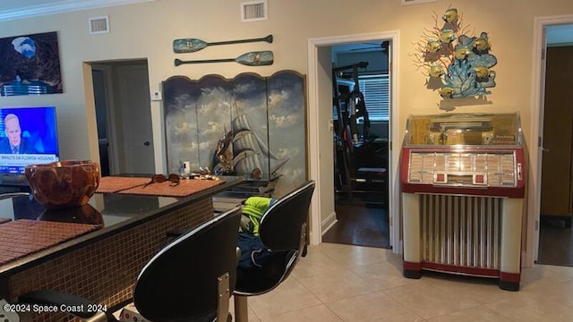 interior space featuring ornamental molding and light tile patterned flooring