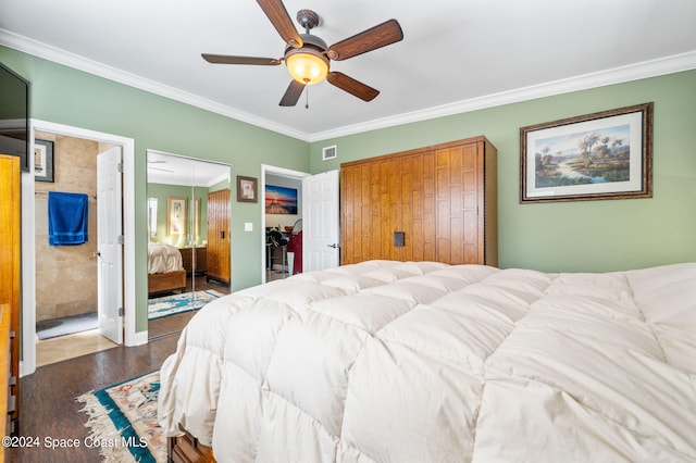 bedroom with dark wood-type flooring, ceiling fan, crown molding, and two closets