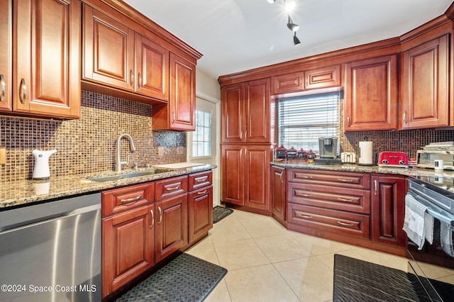 kitchen with tasteful backsplash, light stone counters, light tile patterned floors, stainless steel dishwasher, and sink