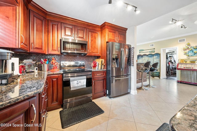 kitchen with appliances with stainless steel finishes, crown molding, light tile patterned flooring, and backsplash