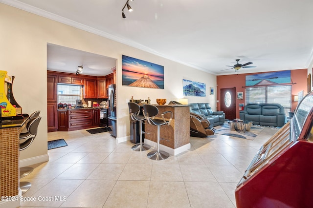 tiled living room featuring ornamental molding and ceiling fan