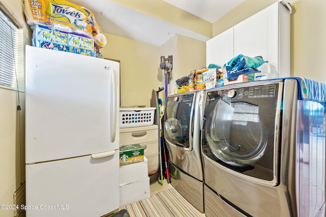 laundry area with independent washer and dryer and cabinets