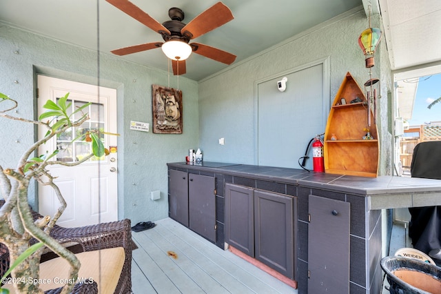 kitchen featuring tile countertops, light wood-type flooring, and ceiling fan