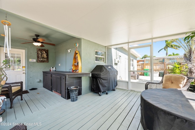 sunroom / solarium featuring ceiling fan