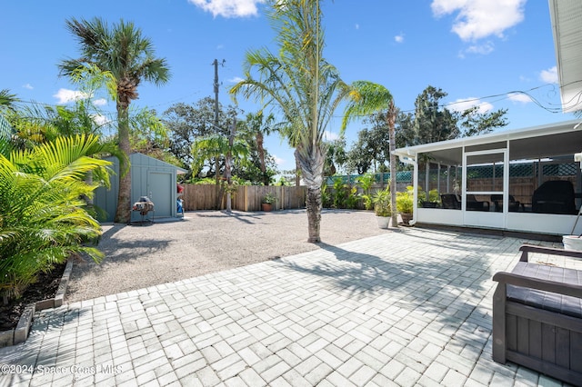 view of patio featuring a sunroom and a storage shed