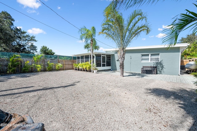 back of property with a patio area and a sunroom