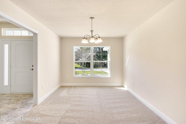 interior space with an inviting chandelier, a textured ceiling, and light carpet