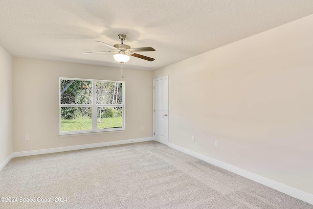 carpeted empty room featuring ceiling fan and a textured ceiling