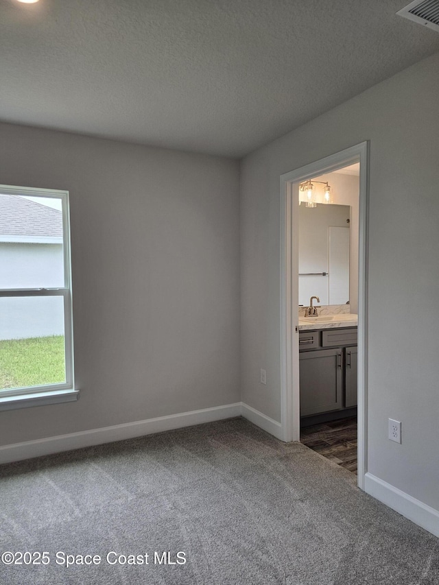 843 Geary St SW, Palm Bay, FL 32908 - spare room with dark colored carpet, baseboards, a textured ceiling, and a sink