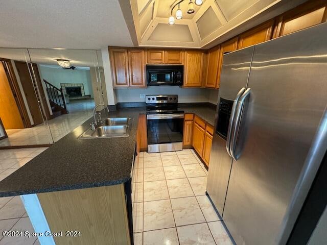 kitchen featuring appliances with stainless steel finishes, kitchen peninsula, sink, and light tile patterned flooring